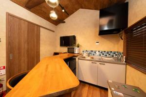 eine Küche mit einer hölzernen Arbeitsplatte in einem Zimmer in der Unterkunft 三十三Daichi in Wada