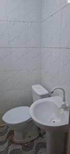 a white bathroom with a toilet and a sink at Apartamento in Belém
