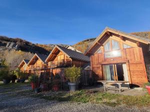 une rangée de maisons en bois dans une cour dans l'établissement Chalet 6 pers avec SPA, terrasse plein sud à Saint-Michel-de-Chaillol - FR-1-393-22, à Saint-Michel-de-Chaillol 6 autres photos
