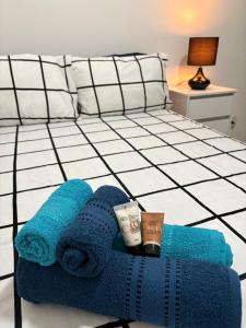 リオデジャネイロにあるApartment near the beachの青いタオルとカップが置かれたベッド