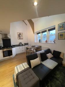 a living room with a couch and a kitchen at The Loft St Austell in St Austell +13 photos