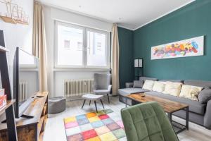 オスナブリュックにあるModernes 72qm Apartment zentral mit Küche und Boxspringbettのソファとテーブルのあるリビングルーム