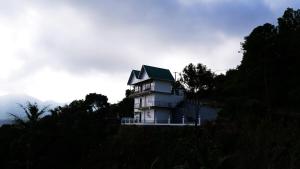 a house with a green roof on top of a hill at Elora Homes in Vagamon
