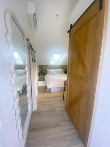 Una puerta corrediza de granero en un dormitorio con una cama. en Chambre Chic et Charme dans Moulin, en Rouessé-Vassé 7 fotos más