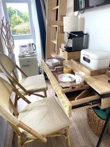 cocina con mesa, 2 sillas y barra en Chambre Chic et Charme dans Moulin, en Rouessé-Vassé