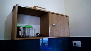 a wooden cupboard with drinks in it at Elora Homes in Vagamon