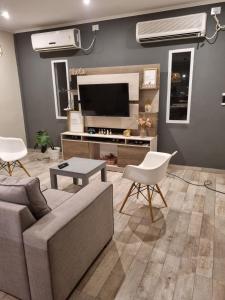 a living room with a couch and a flat screen tv at Quincho Sauco en Colonia Benitez in Colonia Benítez