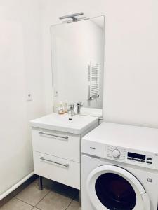 ラ・クールヌーヴにあるLogement La courneuve-Aubervilliers RerBの白いランドリールーム(洗濯機、シンク付)