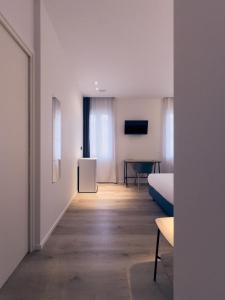 a white room with a bed and a table at Dimora in Prato in Padova