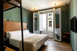 a bedroom with a bed and a balcony with a television at Colectia Stays Atocha in Madrid
