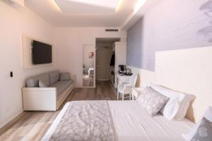 a white bedroom with a bed and a couch at Park Hotel Cellini in Lido di Jesolo +87 photos