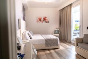 a bedroom with a bed and a couch and a window at Park Hotel Cellini in Lido di Jesolo