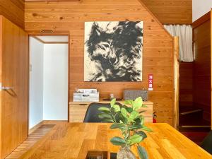 ein Esszimmer mit einem Tisch und einem Gemälde an der Wand in der Unterkunft The Black Wolf in Hakuba