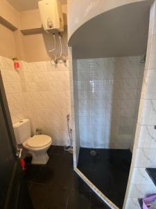 a bathroom with a toilet and a shower stall at 2 Bedroom Subhadra Bhavan in mayapur