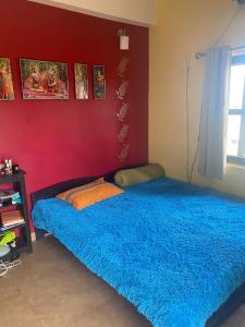 a bedroom with a bed with a blue blanket at 2 Bedroom Subhadra Bhavan in mayapur
