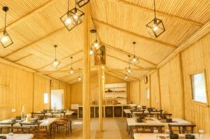 a dining room with tables and chairs and lights at The Woods Resort by Travelista in Nainital