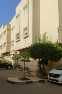 une voiture blanche garée devant un immeuble dans l'établissement Lalla fatima Avenue Bayrout Monfleurie 2, à Fès