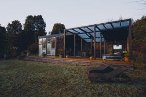 una casa con un banco delante de ella en Ampe Lodge, en Puerto Varas 9 fotos más