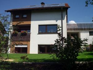 une maison avec un balcon fleuri dans l'établissement Ferienwohnung Familie Balko, à Herdringen