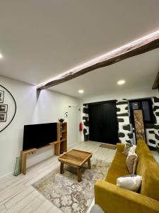 een woonkamer met een bank en een flatscreen-tv bij The Mill House in Lagoa