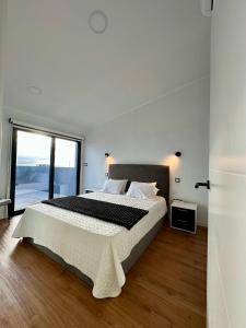 a bedroom with a large bed and a large window at The Mill House in Lagoa