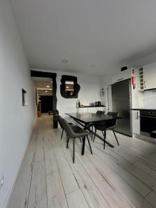 een eetkamer met een tafel en een keuken bij The Mill House in Lagoa