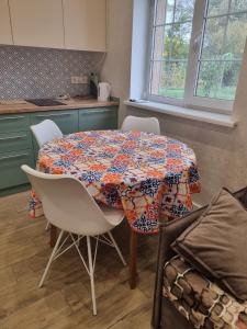 a kitchen with a table with chairs and a tablecloth on it at GreekХата in Myrhorod +5 photos