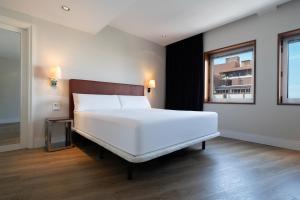 a bedroom with a large white bed and a window at Hotel Palma Avenidas in Palma de Mallorca
