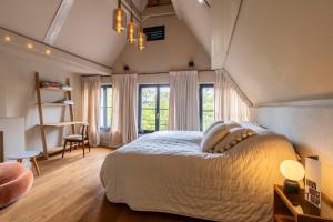 a bedroom with a large bed and some windows at Townhouse 't Raap in Amsterdam