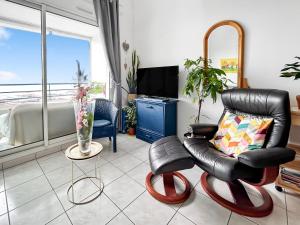 ein Wohnzimmer mit einem Ledersessel und einem TV in der Unterkunft Vue mer panoramique, Loggia Salon, Parking Privé in Saint-Hilaire-de-Riez