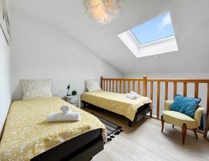 ein Schlafzimmer mit zwei Betten, einem Stuhl und einem Fenster in der Unterkunft Vue mer panoramique, Loggia Salon, Parking Privé in Saint-Hilaire-de-Riez