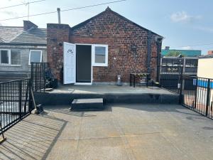 a brick house with a white door and a gate at Westfield Street in Saint Helens