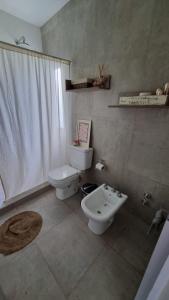 un baño con inodoro y lavabo en Quincho Sauco en Colonia Benitez, en Colonia Benítez