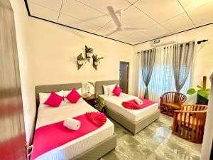 two beds in a room with red pillows at Double W Grand Villa Madiha in Matara