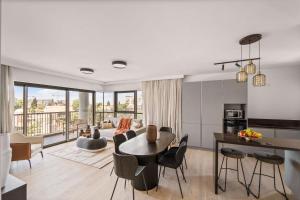 una sala de estar con una mesa y sillas en Savyon View 2 Bdr By Isrentals, en El Muṣrāra