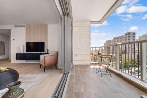 sala de estar con balcón con vistas a la ciudad en Savyon View 2 Bdr By Isrentals, en El Muṣrāra