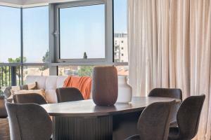 Una mesa y sillas en una habitación con ventana. en Savyon View 2 Bdr By Isrentals, en El Muṣrāra