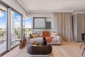 una sala de estar con un sofá y una mesa en Savyon View 2 Bdr By Isrentals, en El Muṣrāra