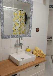 a bathroom with a white sink and a mirror at Casa de Limón - סוויטות בוטיק וספא יוקרתיות בגליל העליון in Sede Eli‘ezer