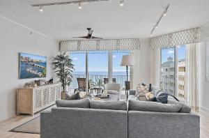 een woonkamer met een bank en uitzicht op de oceaan bij Luxurious Three-Bedroom Oceanfront Penthouse with Resort Amenities in Selhaven