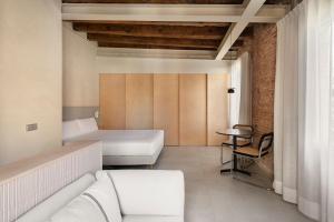 una habitación con un sofá y una cama y una mesa en Decô Apartments Barcelona-Born St., en Barcelona