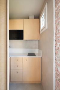 una cocina con armarios de madera y una pared de ladrillo en Decô Apartments Barcelona-Born St., en Barcelona