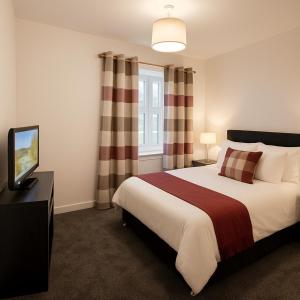 een slaapkamer met een groot bed en een televisie bij St Michaels House in Leeds