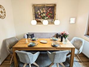 a dining room table with chairs and a painting on the wall at Ferienhaus am Gässchen in Edesheim +45 photos