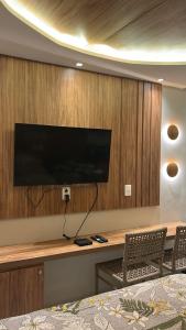a room with a desk with a television on a wall at Flat - Beira-Mar - Piscina - Intermares in Cabedelo +30 photos