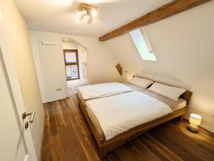 a bedroom with a large bed with white sheets at Ferienhaus am Gässchen in Edesheim