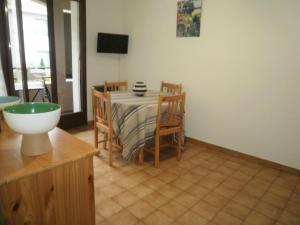 eine Küche mit einem Tisch und Stühlen sowie einem TV in der Unterkunft 2PA80 - studio dans résidence avec piscine in Collioure
