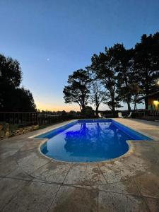 タンディルにあるCabañas Rocasの木々が茂る庭のスイミングプール