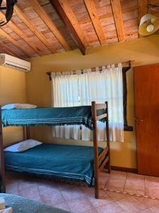 タンディルにあるCabañas Rocasの二段ベッドが2つと窓のある部屋