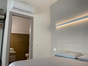 a bedroom with a bed and a mirror and a bathroom at Pietre del mare in Civitanova Marche